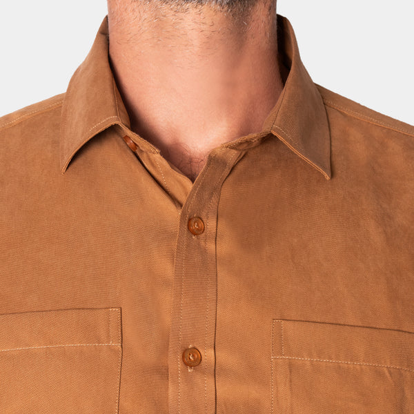 Detalle del cuello, botones y bolsillos en el pecho de la camisa marrón, en modelo | hover: Marrón