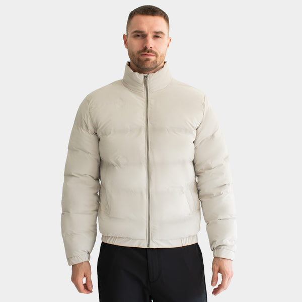 Modelo de frente con chamarra acolchada color hueso y cuello alto cerrado | hover: Hueso